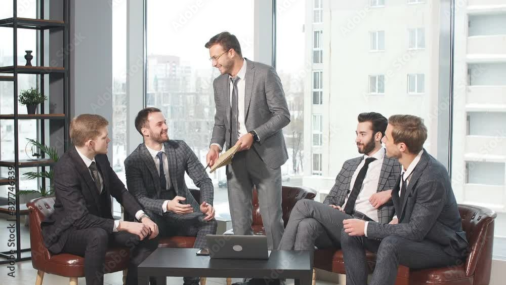 Young caucasian business colleagues sit on leather chairs and discuss together in modern office, wearing elegant suits. big panoramic window in the background Young caucasian business colleagues sit on leather chairs and discuss together in modern office, wearing elegant suits. big panoramic window in the background