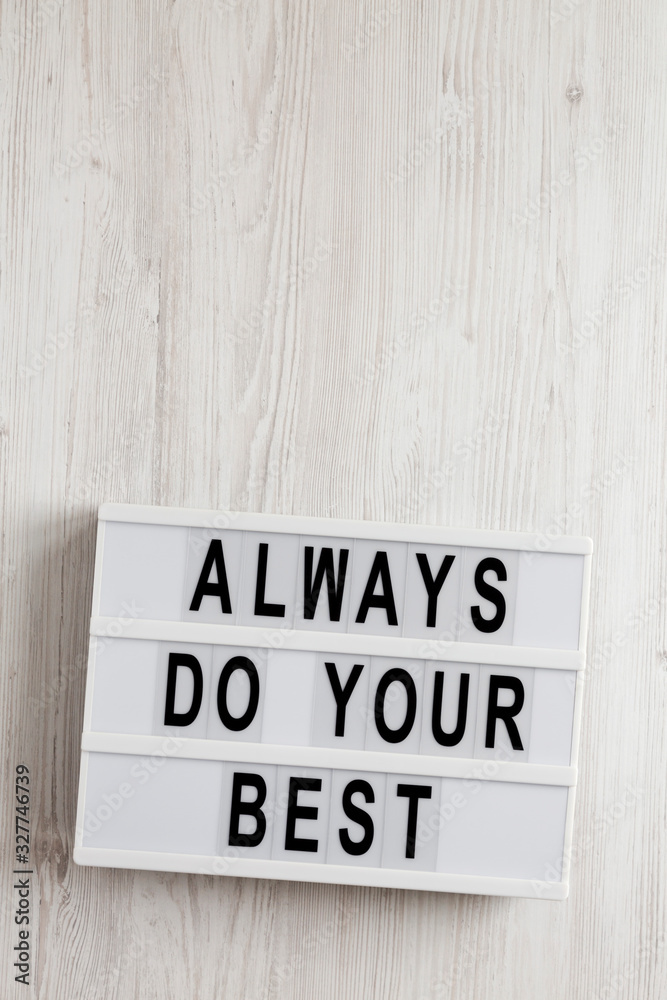 'Always do your best' words on a lightbox on a white wooden surface, top view. Overhead, from above, flat lay. Copy space.