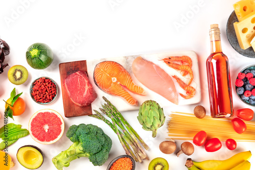 Food, a flat lay of many different products, with meat, fish, chicken and shrimps, vegetables and fruits, wine and cheese, shot from the top on a white background with a place for text