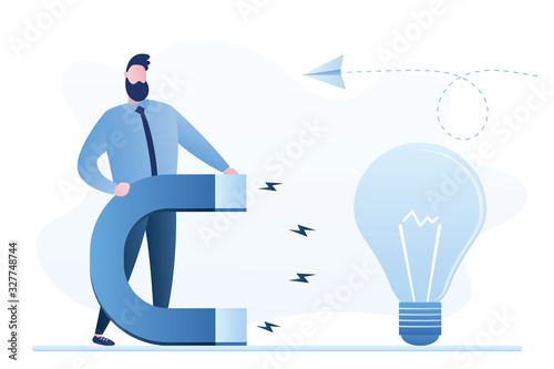 Handsome businessman holding with a huge magnet attracting idea bulb. Brainstorming and new ideas concept.