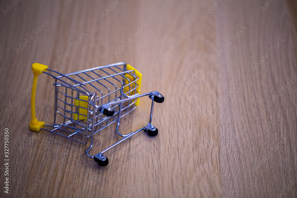 Fototapeta premium overturned grocery cart on the wooden surface