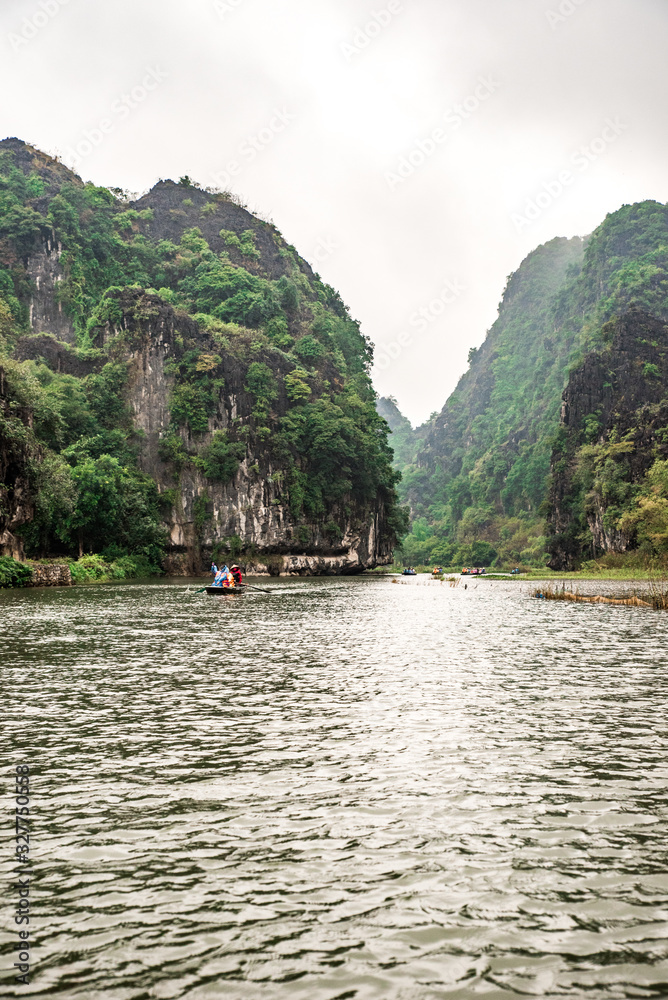 Tam Coc National Park - Tourists traveling in boats along the Ngo Dong River at Ninh Binh Province, Trang An landscape complex, Vietnam - Landscape formed by karst towers and rice fields Tam Coc National Park - Tourists traveling in boats along the Ngo Dong River at Ninh Binh Province, Trang An landscape complex, Vietnam - Landscape formed by karst towers and rice fields