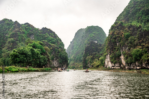 Tam Coc National Park - Tourists traveling in boats along the Ngo Dong River at Ninh Binh Province, Trang An landscape complex, Vietnam - Landscape formed by karst towers and rice fields © Simon Dannhauer