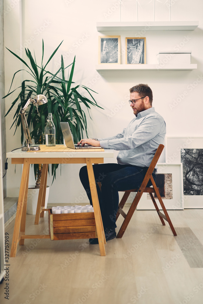 Young male architect sitting at his desk and typing. Young male architect sitting at his desk and typing.