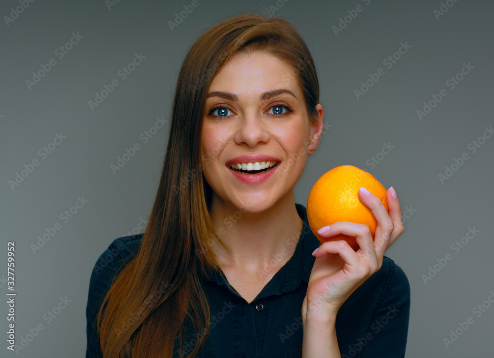 Smiling woman holding whole orange.