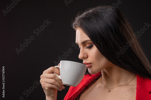 Beautiful happy woman drinking a cup of coffee