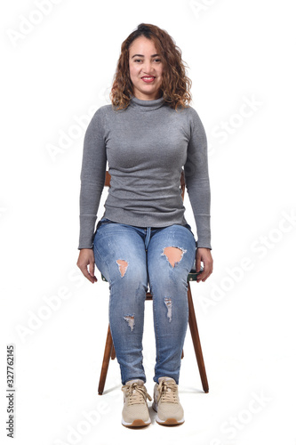 portrait of a woman sitting on a chair in white background, looking at camera photo