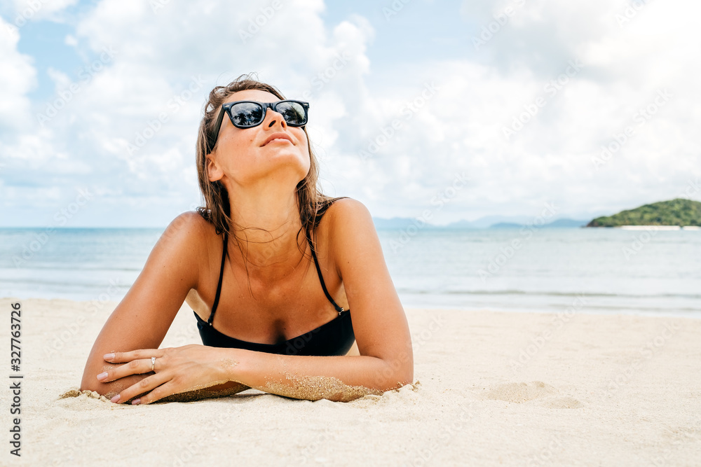 Beautiful woman lying down on the beach sand Beautiful woman lying down on the beach sand