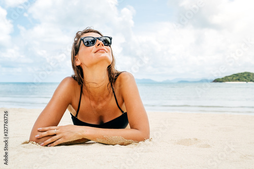 Beautiful woman lying down on the beach sand