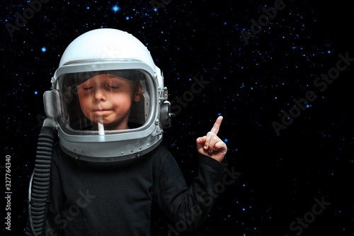 A small child imagines himself to be an astronaut in an astronaut's helmet. © vovan