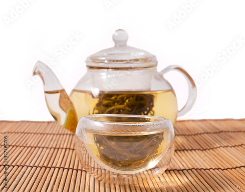 Teapot and glass cups with the chinese jasmine tea Mo Li Long Zhu (Jasmine Pearls) isolated on a white background.