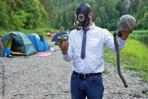 The man in the gas mask on the background of tourist campsites