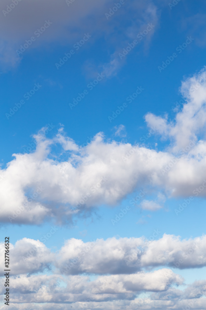 Snow-white fluffy clouds against the blue sky. Vertical. Snow-white fluffy clouds against the blue sky. Vertical.