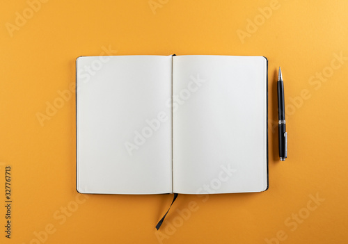 open diary or notebook with blank white pages on orange background template photo