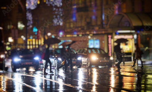 crow of people walking gin the city on rainy night