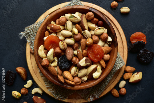 Wooden bowl with assortment of dried fruits and nuts. Top view with copy space.
