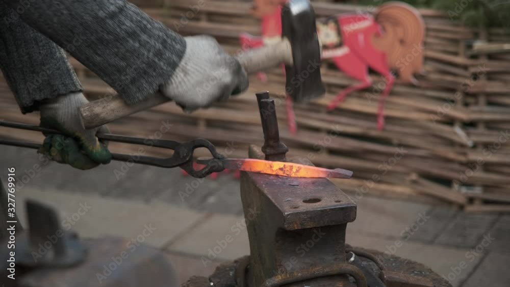 The blacksmith works in the forge. Hot metal, sparks and coals. A fire is burning, metal blanks are melting. The blacksmith works in the forge. Hot metal, sparks and coals. A fire is burning, metal blanks are melting.