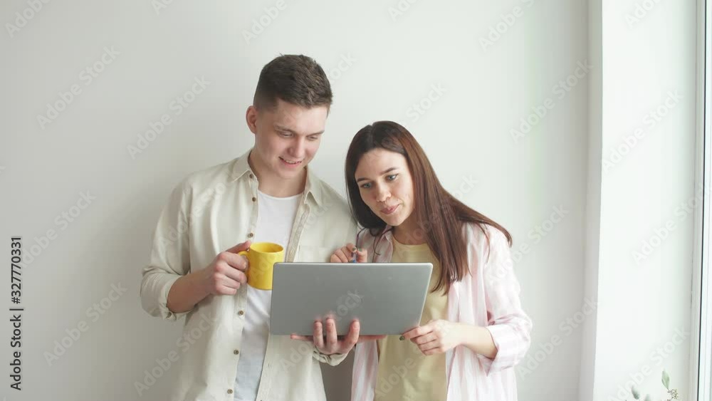 Young good looking programmer fixing woman's computer, man helping woman to work with laptop. Man pointing to the screen. Young good looking programmer fixing woman's computer, man helping woman to work with laptop. Man pointing to the screen.