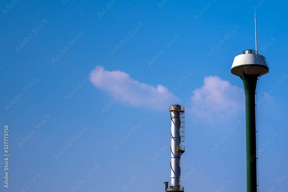 Factory chimney and the water tower tank on blue sky Factory chimney and the water tower tank on blue sky
