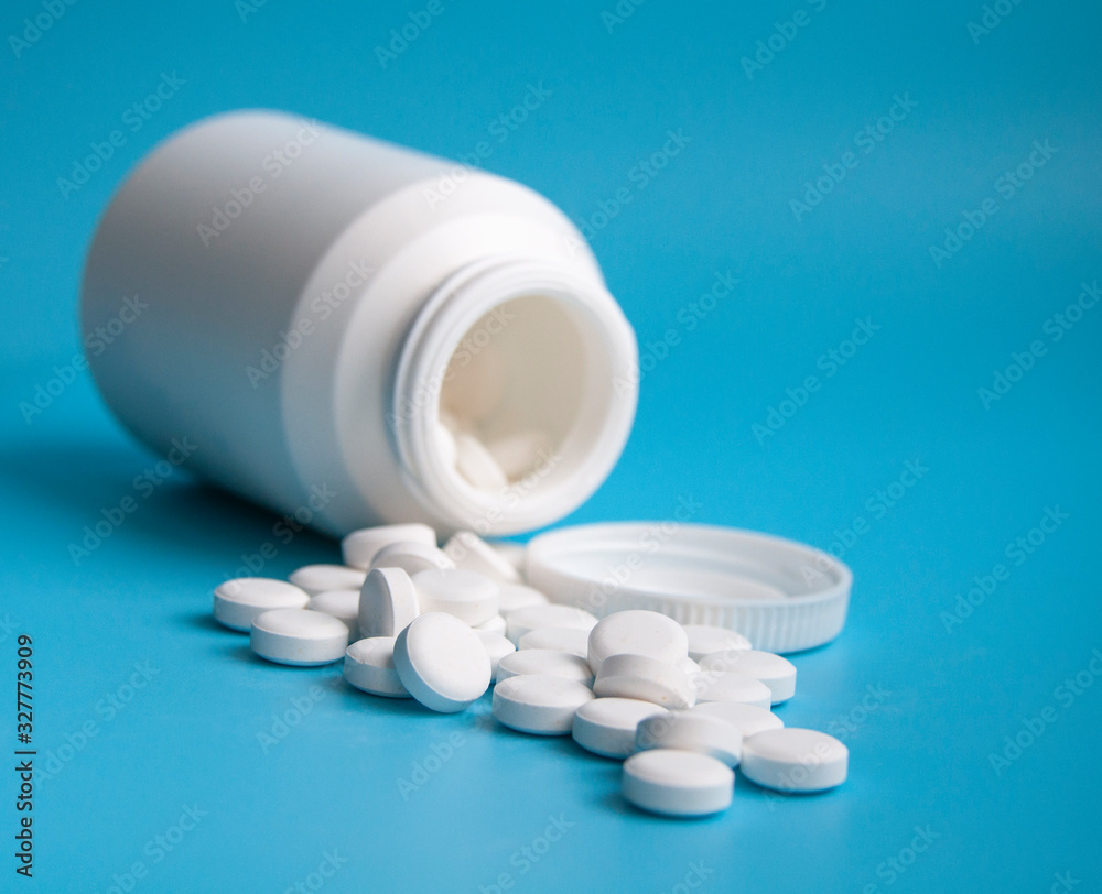 white pills or tablets for virus on blue background white pills or tablets for virus on blue background