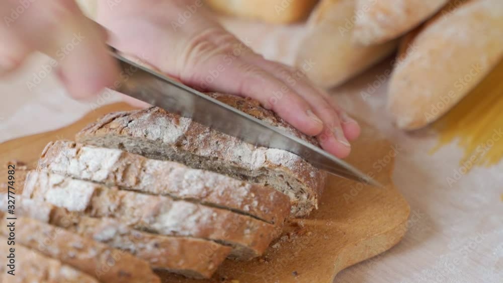 Male hands cutting bread on the wooden board Male hands cutting bread on the wooden board