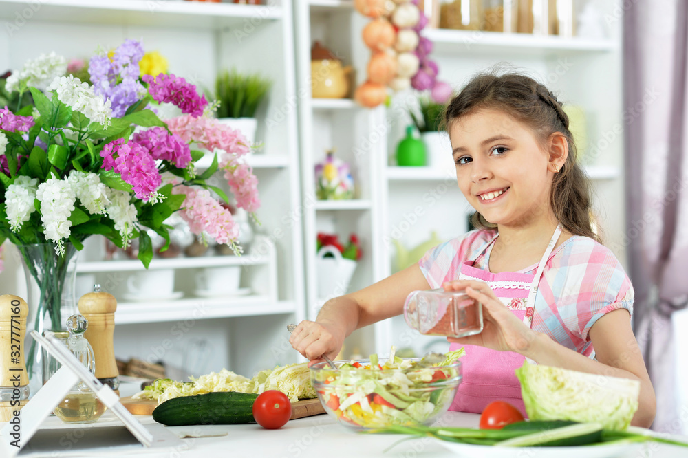 Portrait of cute little girl preparing fresh salad