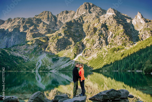 a couple are in the mountains near a lake