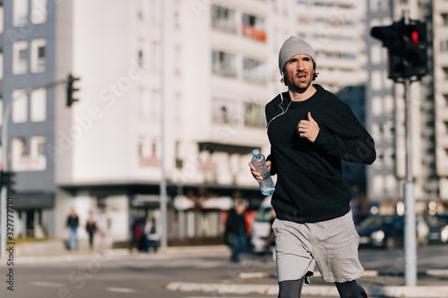 Young athletic man running in the city.