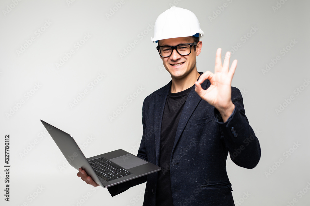 Portrait of an engineer with okay sign using a laptop isolated on white background Portrait of an engineer with okay sign using a laptop isolated on white background