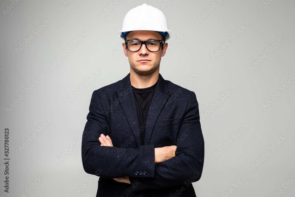 Confident man engineer wearing protective helmet holding hands crossed looking away isolated over white background. Confident man engineer wearing protective helmet holding hands crossed looking away isolated over white background.