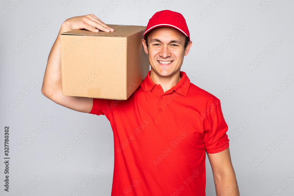 Side view of delivery man with box isolated gray background Side view of delivery man with box isolated gray background