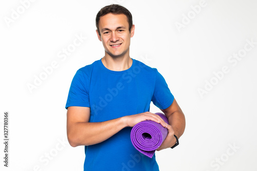 Fitness man holding yoga training mat. Young muscular sporty man on white background.