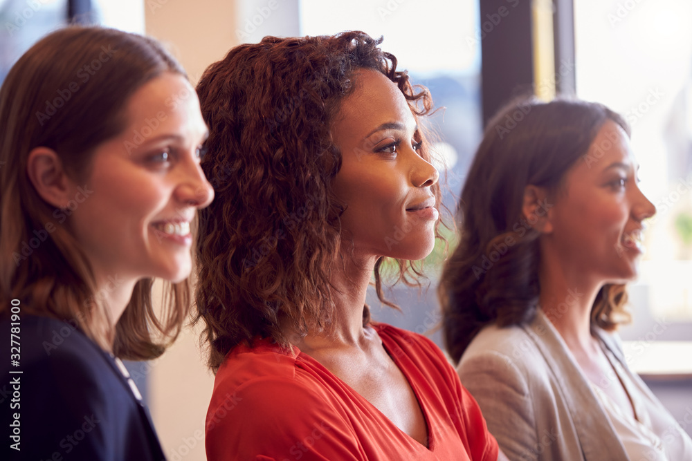 Naklejka premium Three Businesswomen Standing In Modern Open Plan Office Together
