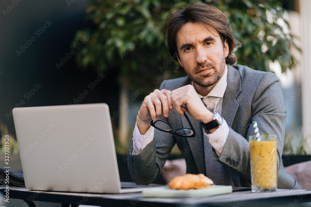 Portrait of young businessman in sitting in outdoor cafe. Portrait of young businessman in sitting in outdoor cafe.