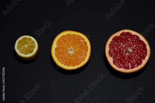 red grapefruit  orange yellow lemon on a black background top view horizontal orientation