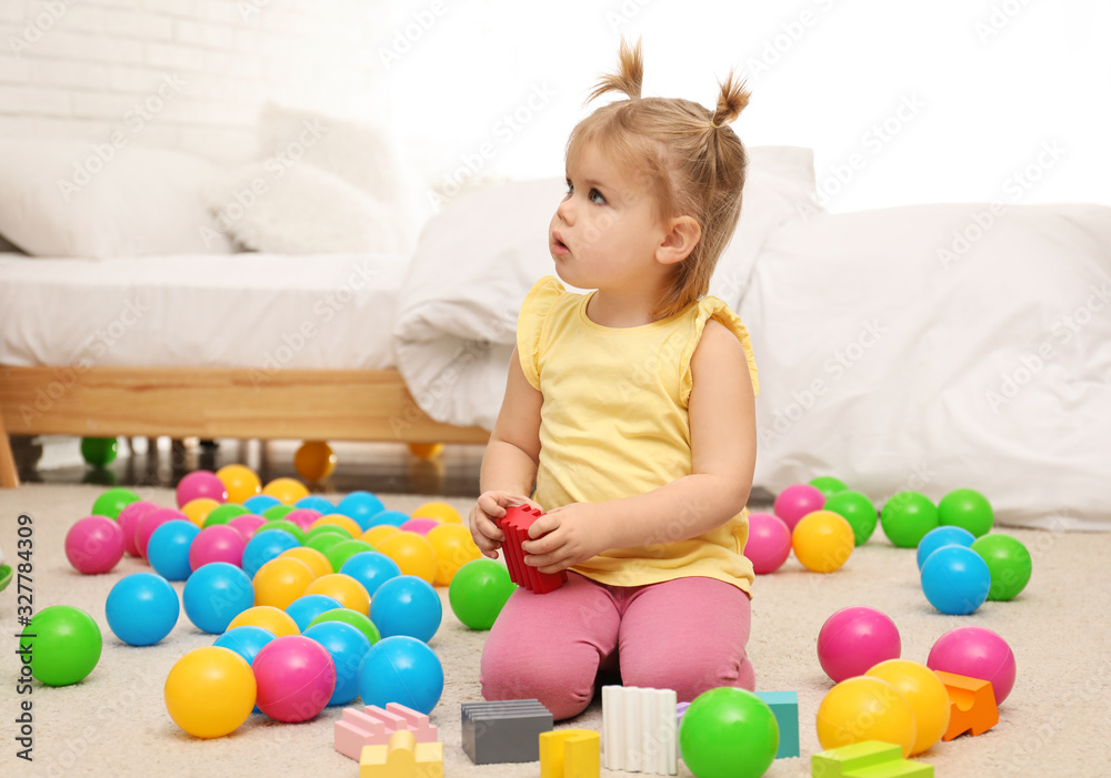 Cute little child playing with toys on floor at home Cute little child playing with toys on floor at home