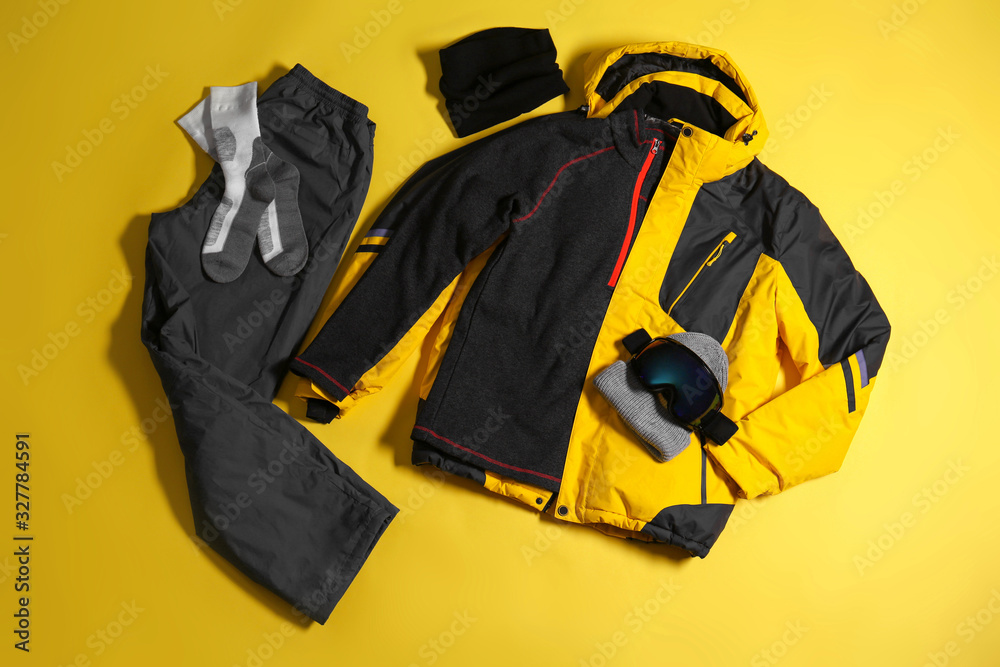 Stylish winter sport clothes on yellow background, flat lay Stylish winter sport clothes on yellow background, flat lay