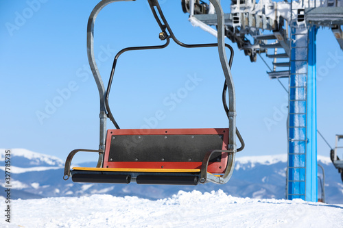 Quadro em tela Empty chairlift at mountain ski resort. Winter vacation
