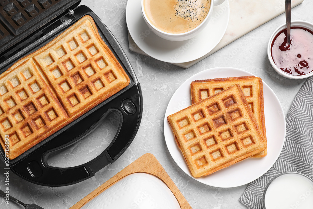 Flat lay composition with fresh Belgian waffles on light grey marble table Flat lay composition with fresh Belgian waffles on light grey marble table