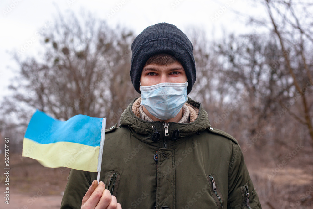 sick masked man with ukraine flag.coronavirus outbreak in Ukraine. pandemic covid-2019 sick masked man with ukraine flag.coronavirus outbreak in Ukraine. pandemic covid-2019