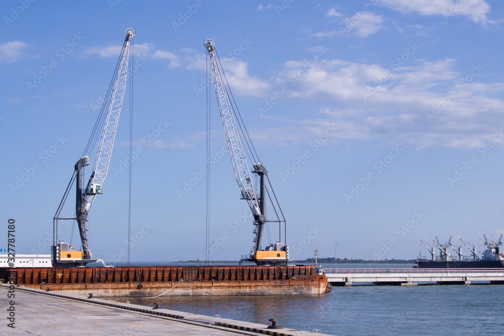 2 units of Harbor Mobile Crane (HMC) are being loaded onto barges 2 units of Harbor Mobile Crane (HMC) are being loaded onto barges