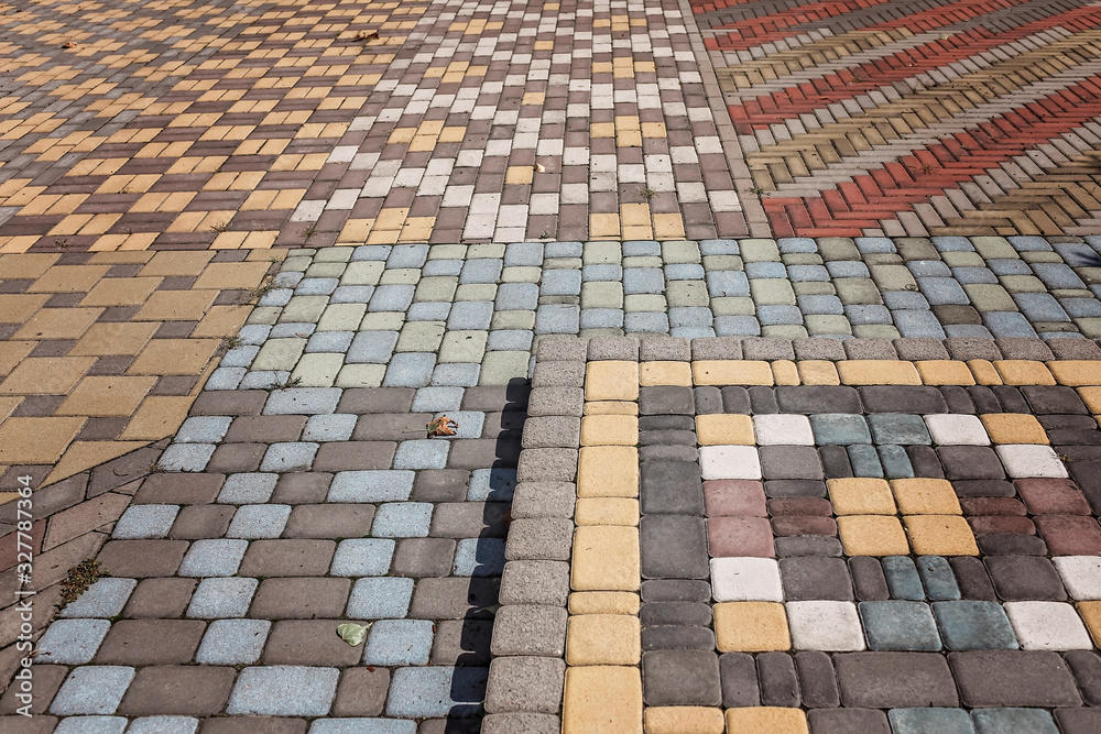 Fototapeta premium Streetlights and texture of different colored patterned paving slabs on the ground of street