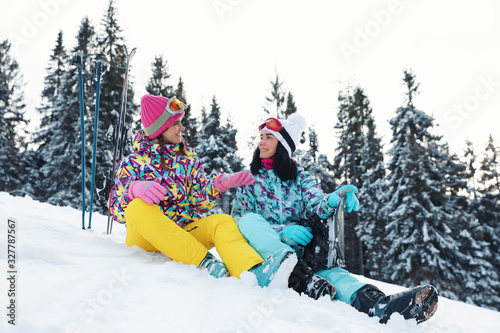 Friends with equipment on snowy hill. Winter vacation