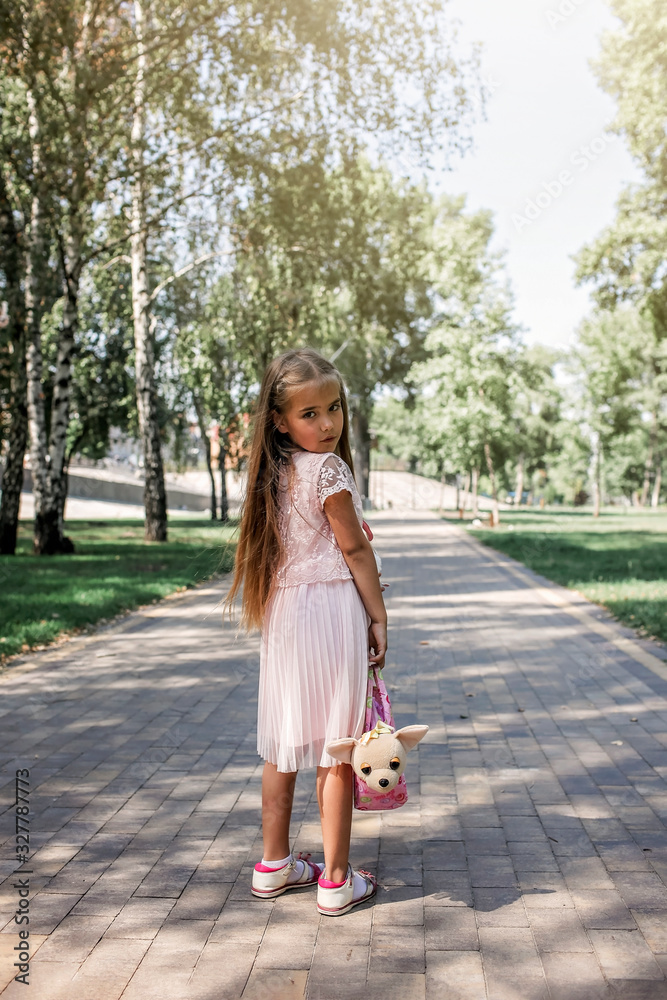 Pretty little lady with long blond hair walking in the park with her little toy pussy pet Pretty little lady with long blond hair walking in the park with her little toy pussy pet