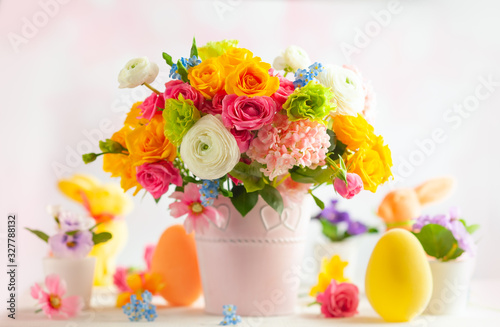 Easter decoration with beautiful spring flowers in vase, Easter eggs and bunn...