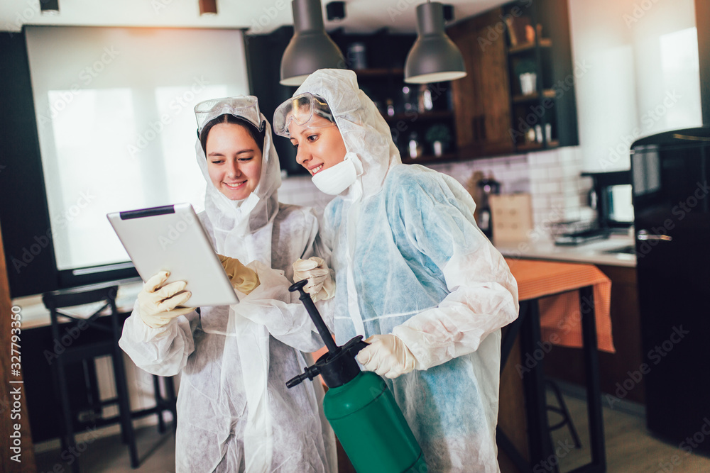 Specialists in protective suits do disinfection or pest control in the apartment. Specialists in protective suits do disinfection or pest control in the apartment.