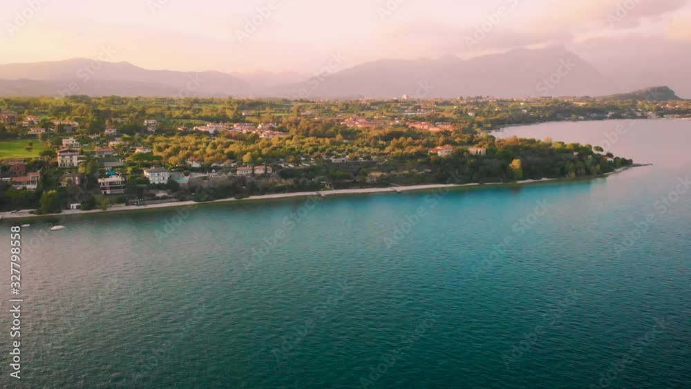 Aerial video with drone. Amazing top view lake Lago di Garda. Fabulous beauty old town of Riva del Garda with red roofs houses green trees, horizon Dolomite Alpine mountains, fly air shooting. Italy Aerial video with drone. Amazing top view lake Lago di Garda. Fabulous beauty old town of Riva del Garda with red roofs houses green trees, horizon Dolomite Alpine mountains, fly air shooting. Italy