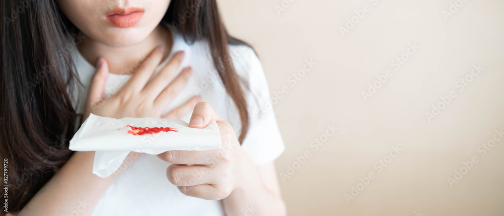 Woman have a coughing up blood and chest pain. Close up of hands holding  tissue paper with bloody sputum. Cause of hemoptysis include TB, lung  cancer, bronchitis, pneumonia or pulmonary embolism. Stock-Foto