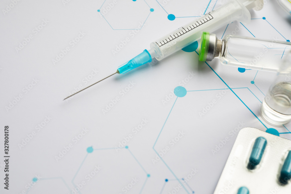 Ampoules and syringe on the science background