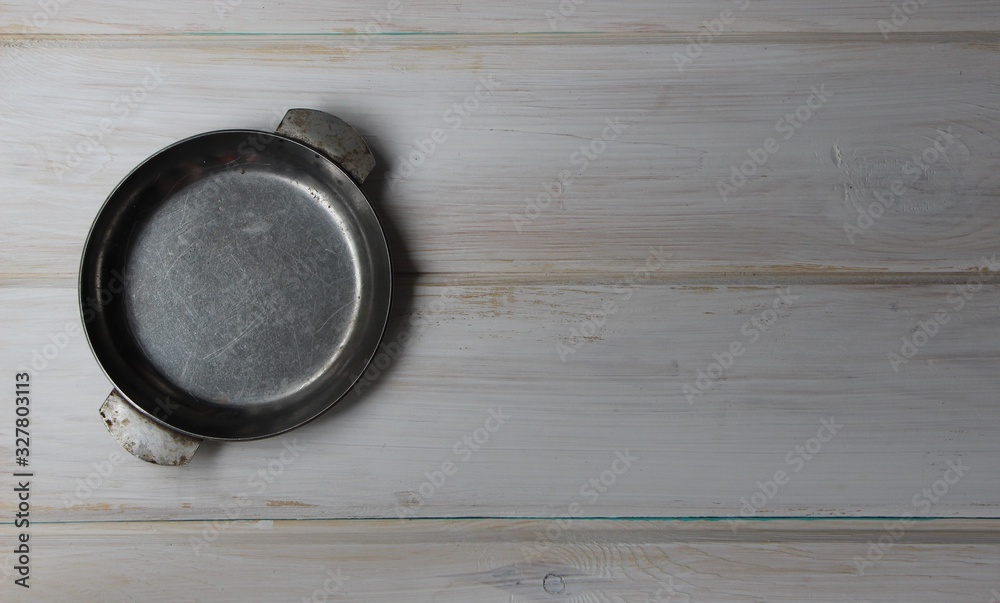 old metal plate on empty light wooden table top view old metal plate on empty light wooden table top view